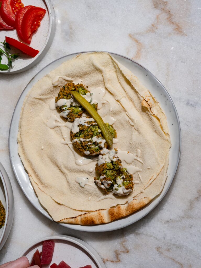 Gurke wird mit in den Falafel Wrap gelegt.