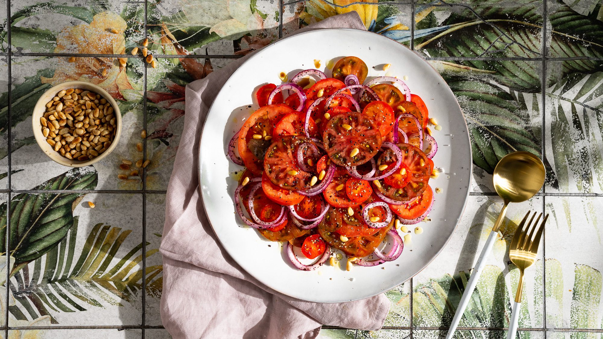 Ensalada de tomate con cebollas de zumaque y piñones | Bistro Badia