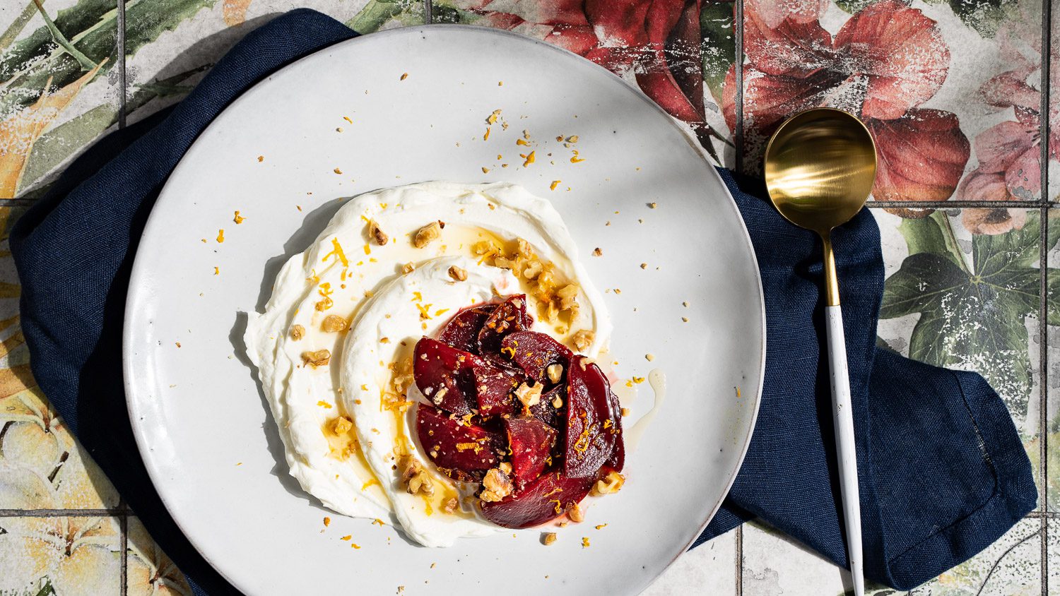 Labneh mit karamellisierter Rote Bete, getoppt mit Walnüssen und Orangenzeste, serviert auf einem hellen Teller.