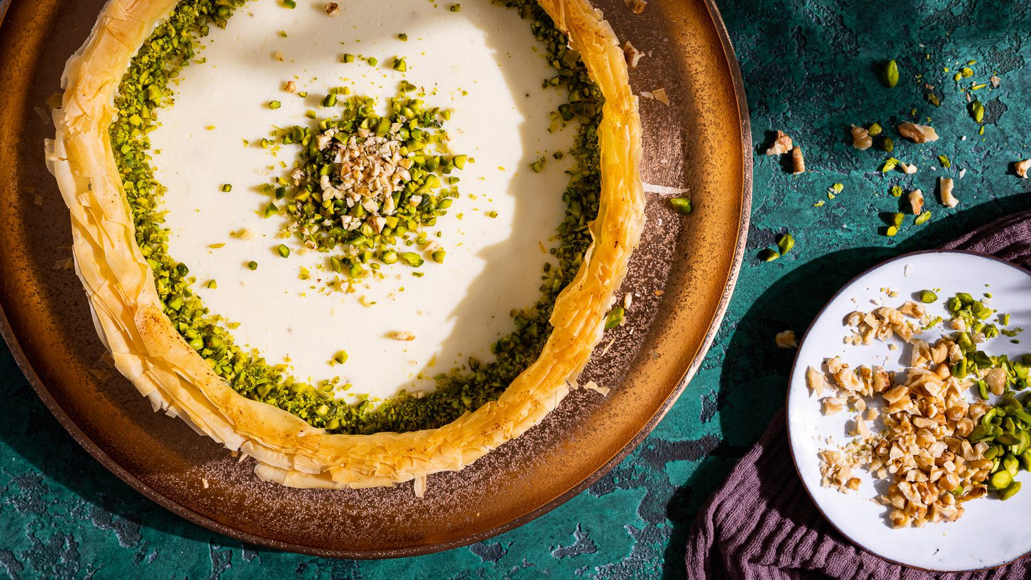 Baklava Cheesecake mit Nüssen auf grünem Untergrund