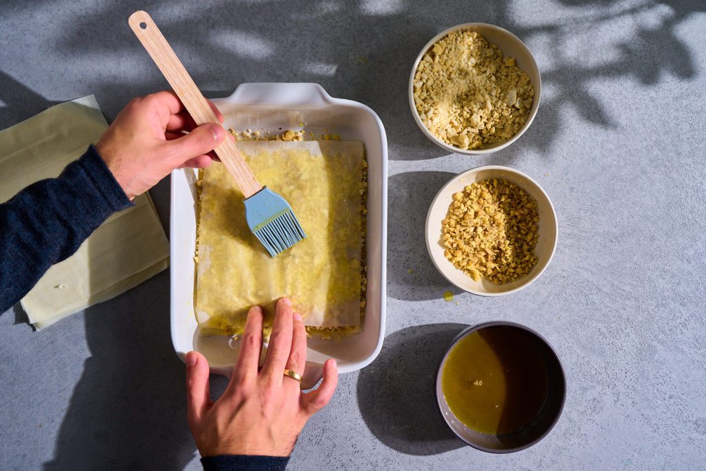 Baklava Rezept: Die letzten Schichten an Filoteig werden mit Ghee eingestrichen. 