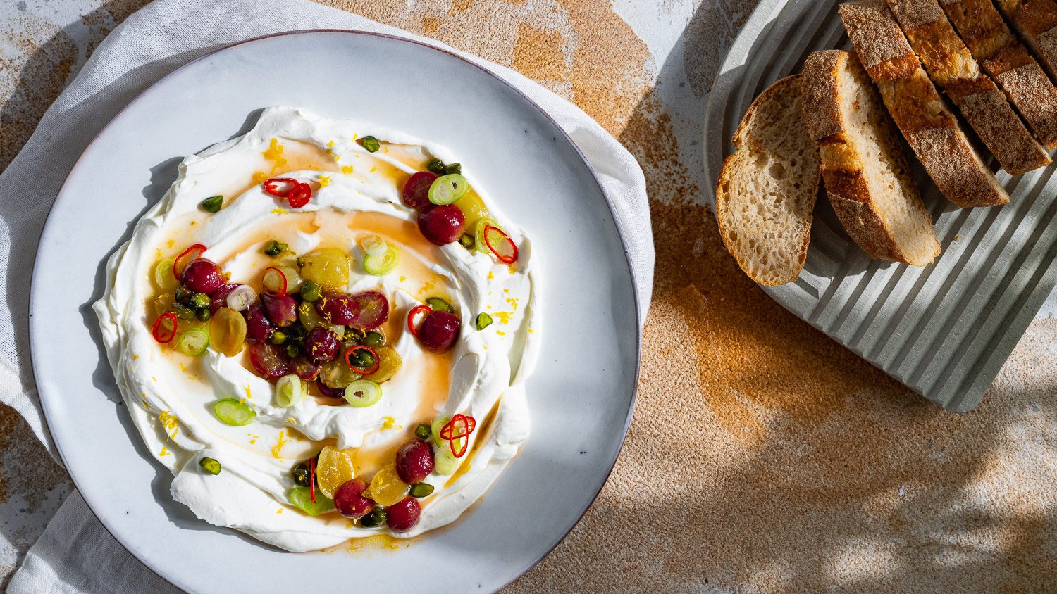 Labneh mit karamellisierten Trauben serviert mit Baguette.