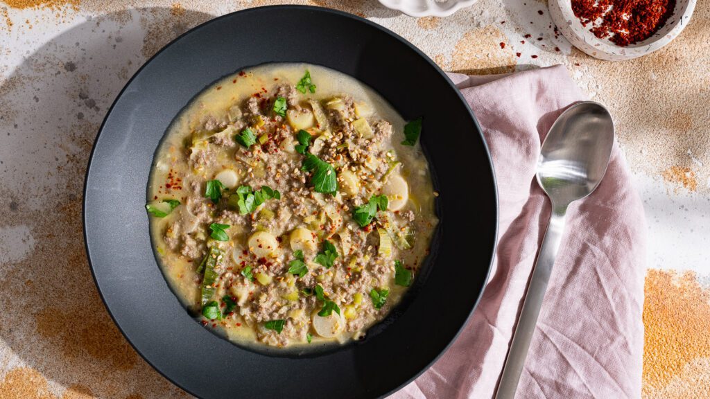 Tahini-Lauchsuppe serviert in einem dunklen Teller.