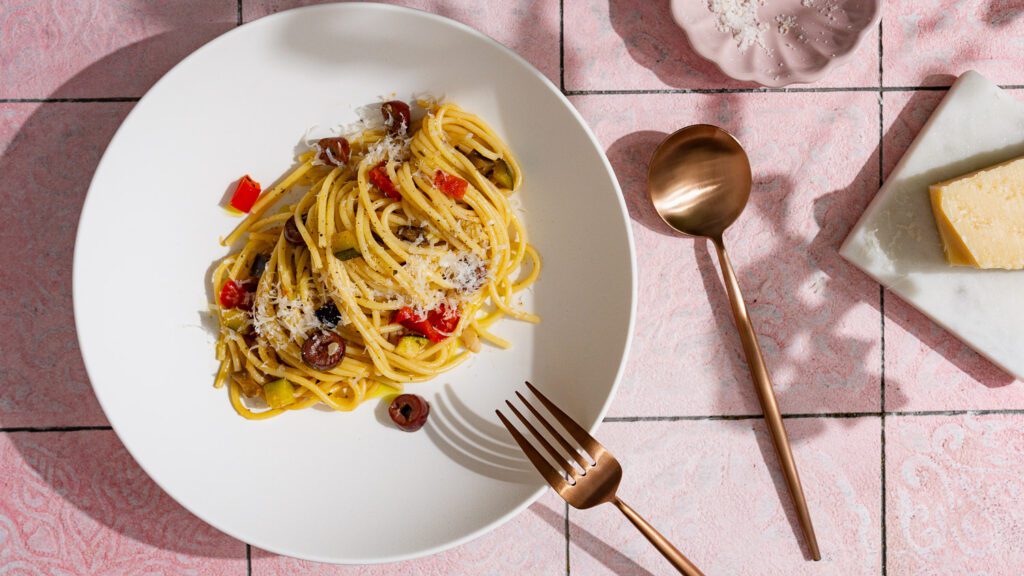 Pasta mit Gemüse angerichtet auf einem weißen Teller.