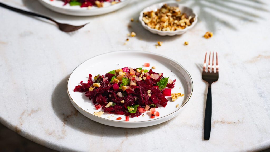 Rote Bete Salat mit Walnüssen auf Tellern angerichtet.