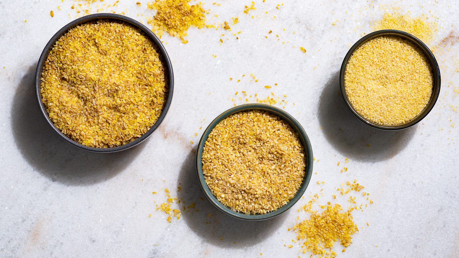 Trois sortes de boulgour sont disposées dans de petits bols sur la table