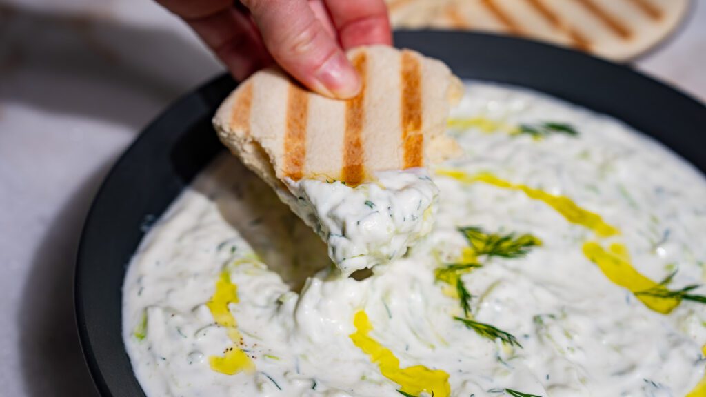Cremoso tzatziki sobre un trozo de pita.