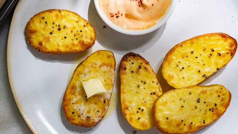 Pommes de terre dorées au four servies sur une assiette avec de la mayo piquante.