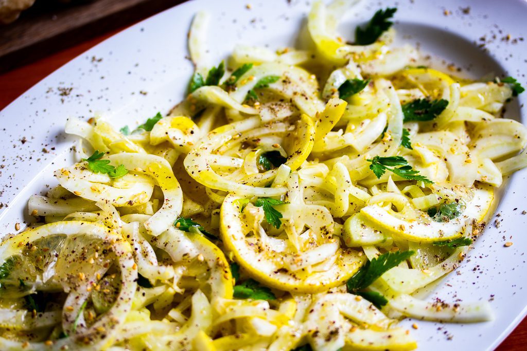 Fenchelsalat mit Zitrone, Petersilie und Cumin auf einem Teller serviert.