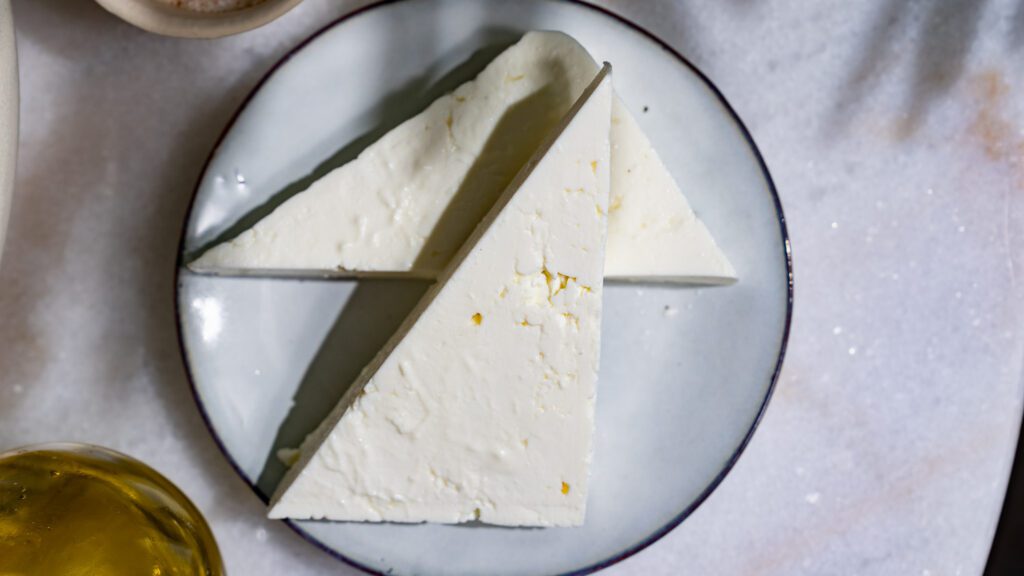 Corta el queso feta en triángulos y sírvelo en un plato.