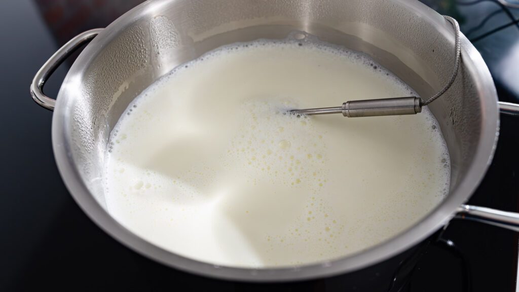 Heat the milk in a pot to make your own yogurt.