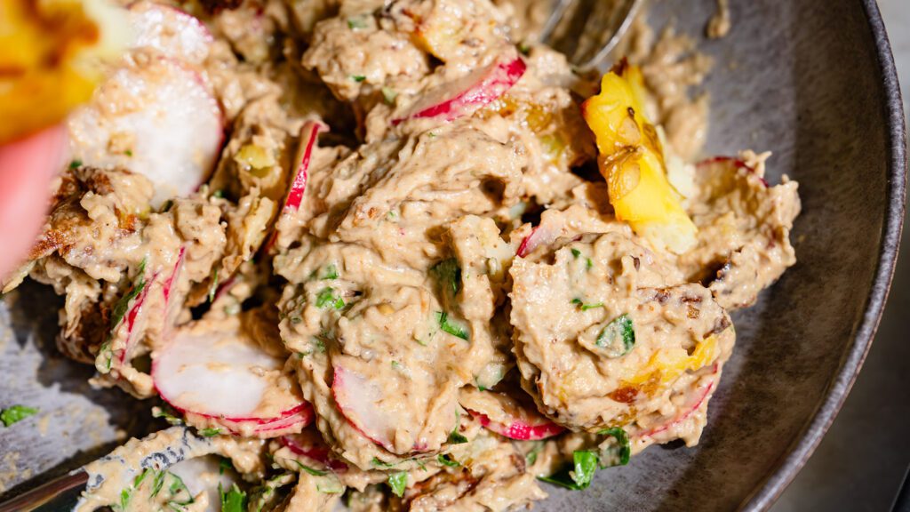 Ensalada de patata triturada mezclada con crema de berenjena.