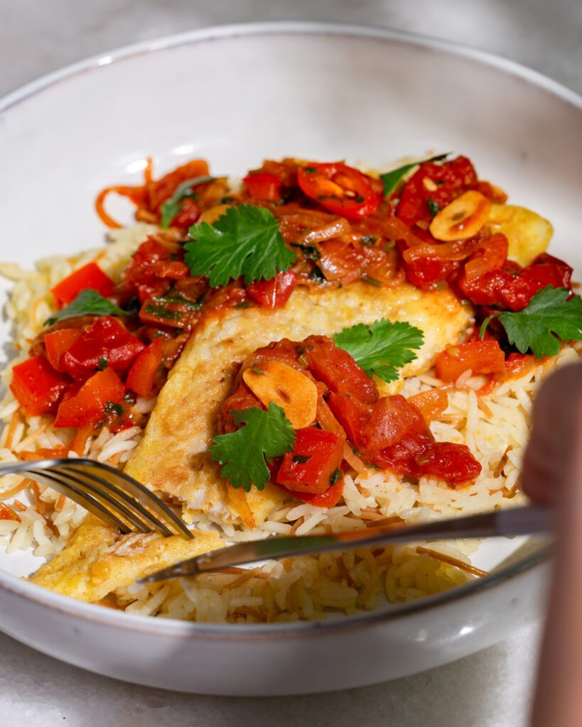 Samke harra served on a plate with buttered rice.
The fish has just been cut.