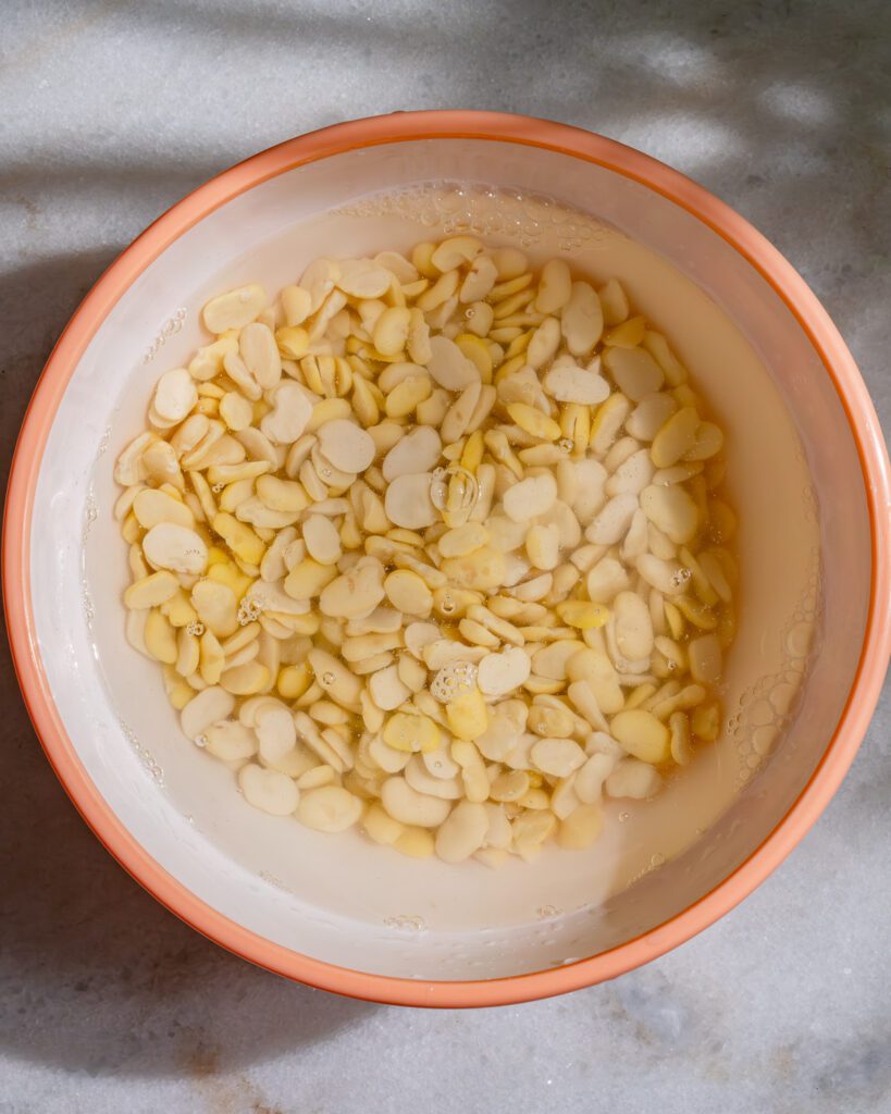 Des haricots fava trempés pour la ta'amia dans un bol.