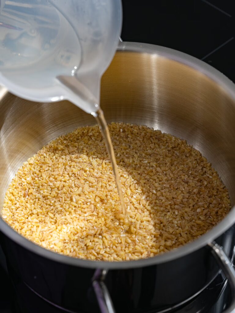 Pour hot water over bulgur in a saucepan to allow it to swell.
