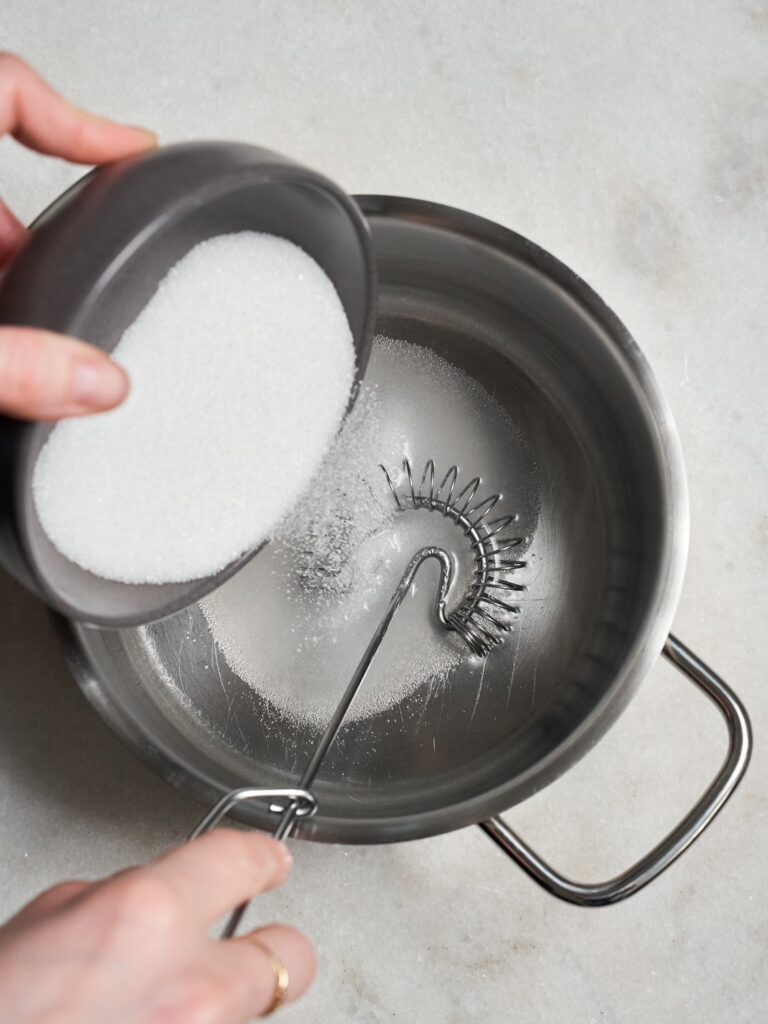 Zucker wird mit Wasser in einem Topf verrührt für das Walnuss-Baklava.