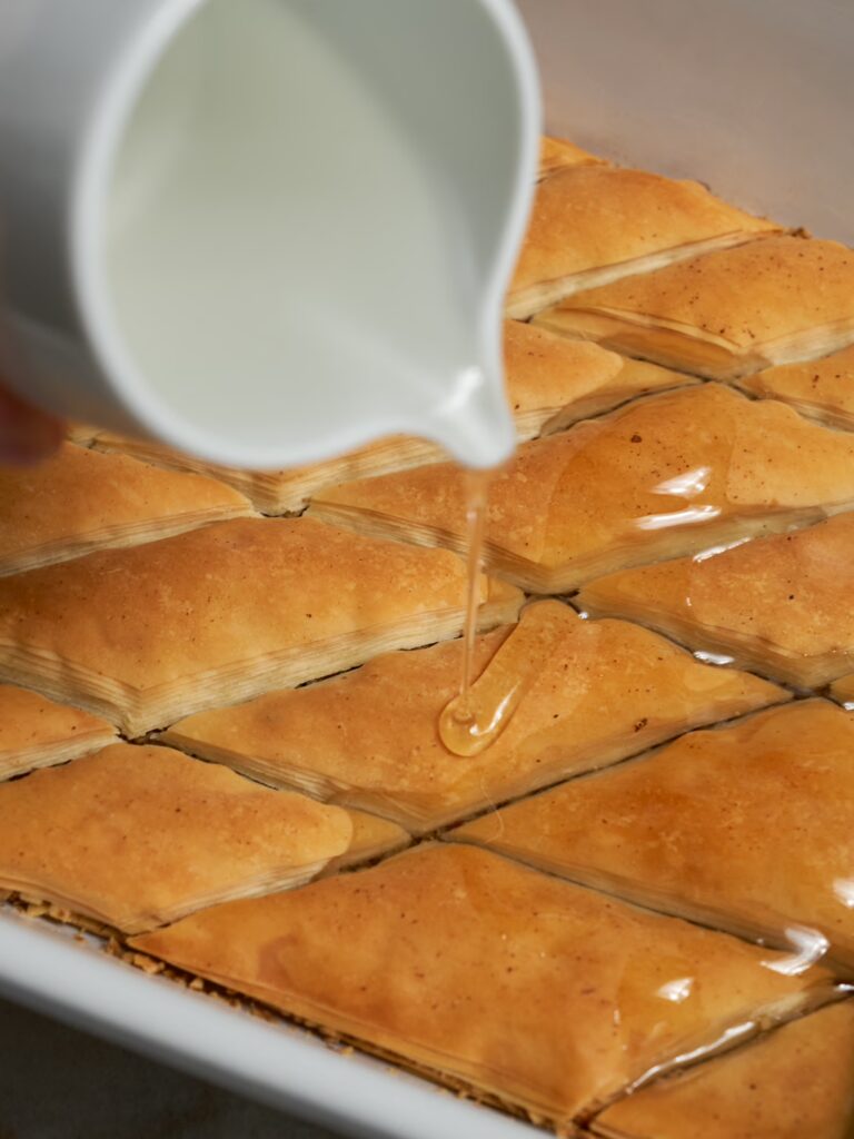 Gebackenes Baklava mit Walnüssen wird noch heiß mit Zuckersirup begossen.