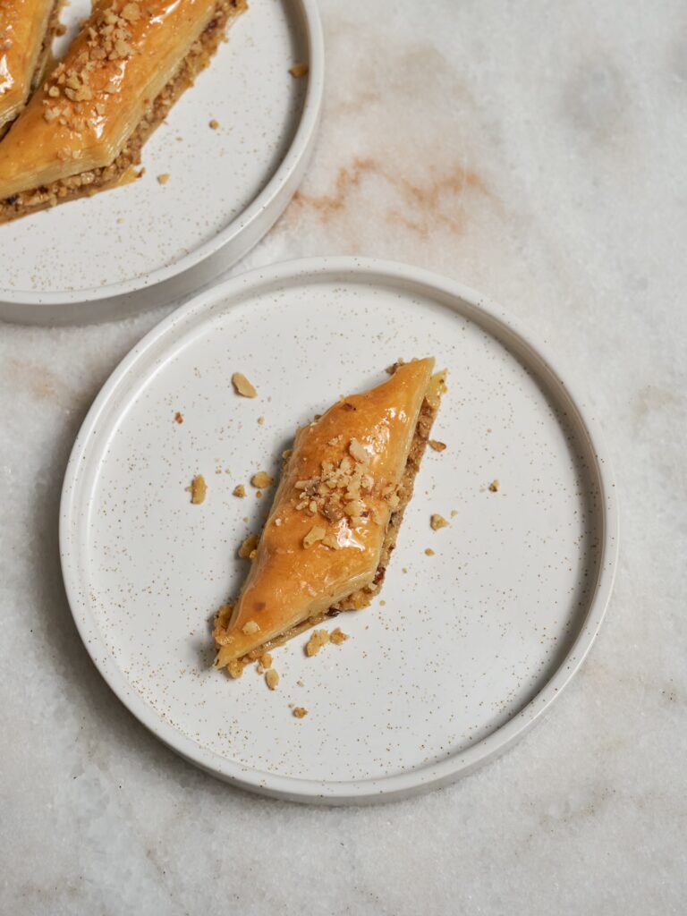 Baklava mit Walnüssen auf zwei kleinen Tellern serviert.