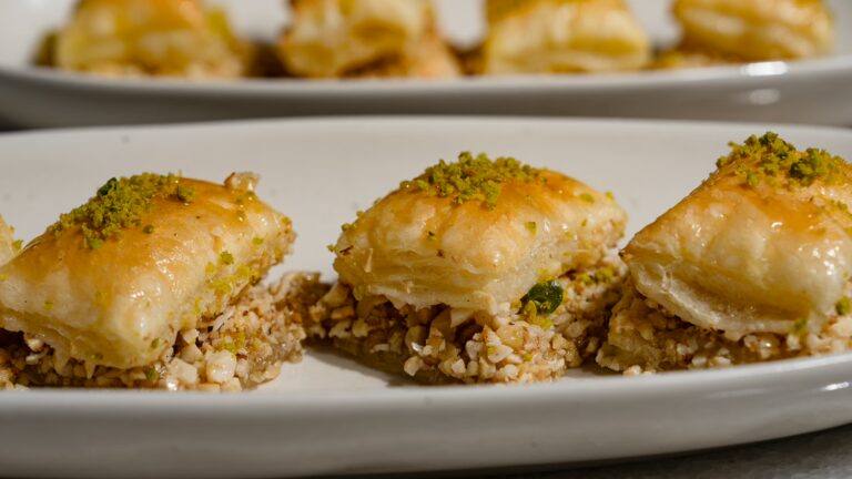 Baklava en pâte feuilletée servi sur une assiette allongée.