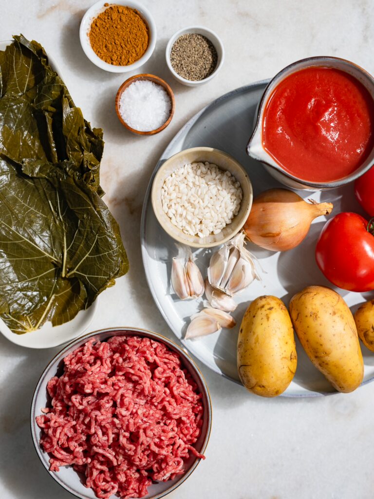 All the ingredients for stuffed vine leaves with minced meat on one table.