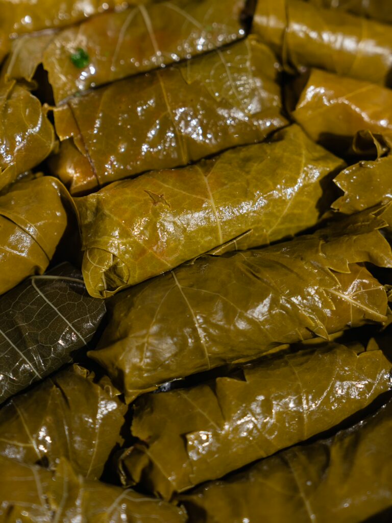 Coloca folhas de videira enroladas num prato.