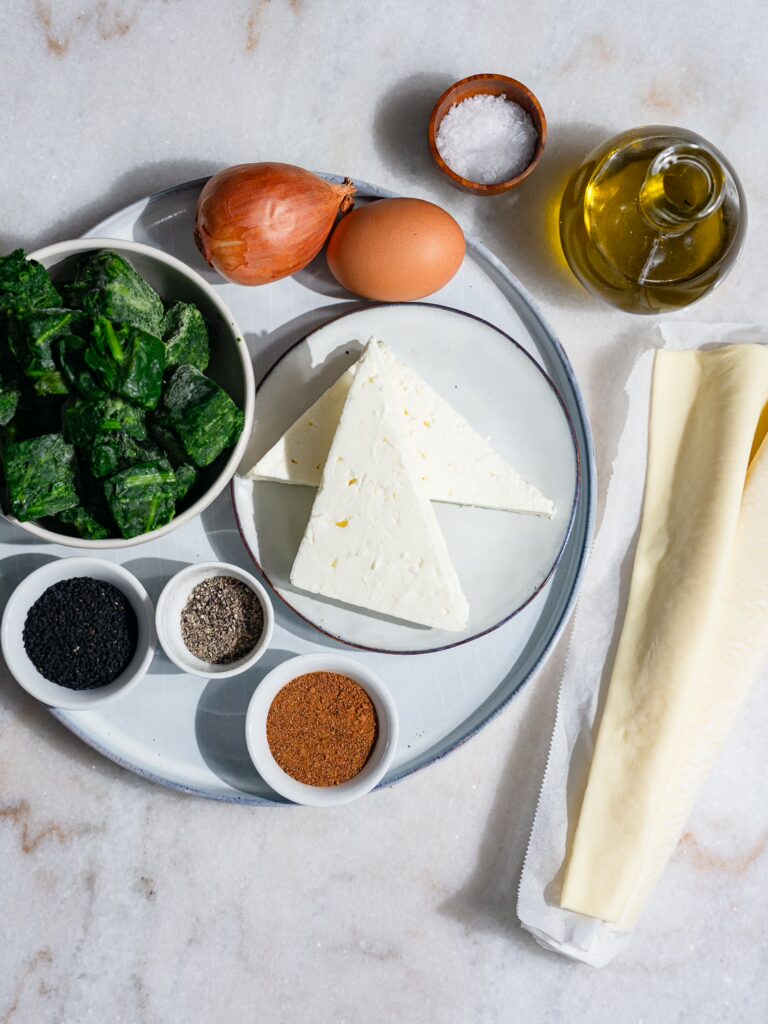 Tous les ingrédients de la pâte feuilletée aux épinards et à la feta sur une seule table