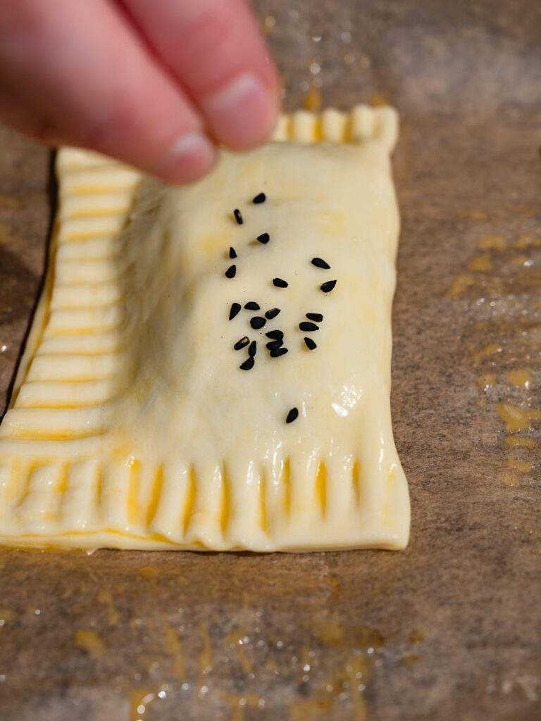La pâte feuilletée aux épinards et à la feta est saupoudrée de graines de nigelle.