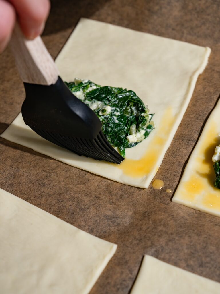 Badigeonnez les bords de la pâte feuilletée avec de l'œuf battu.