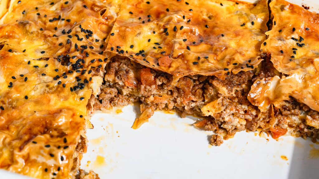 Börek with minced meat baked in the oven until crispy is cut and placed in the tin.