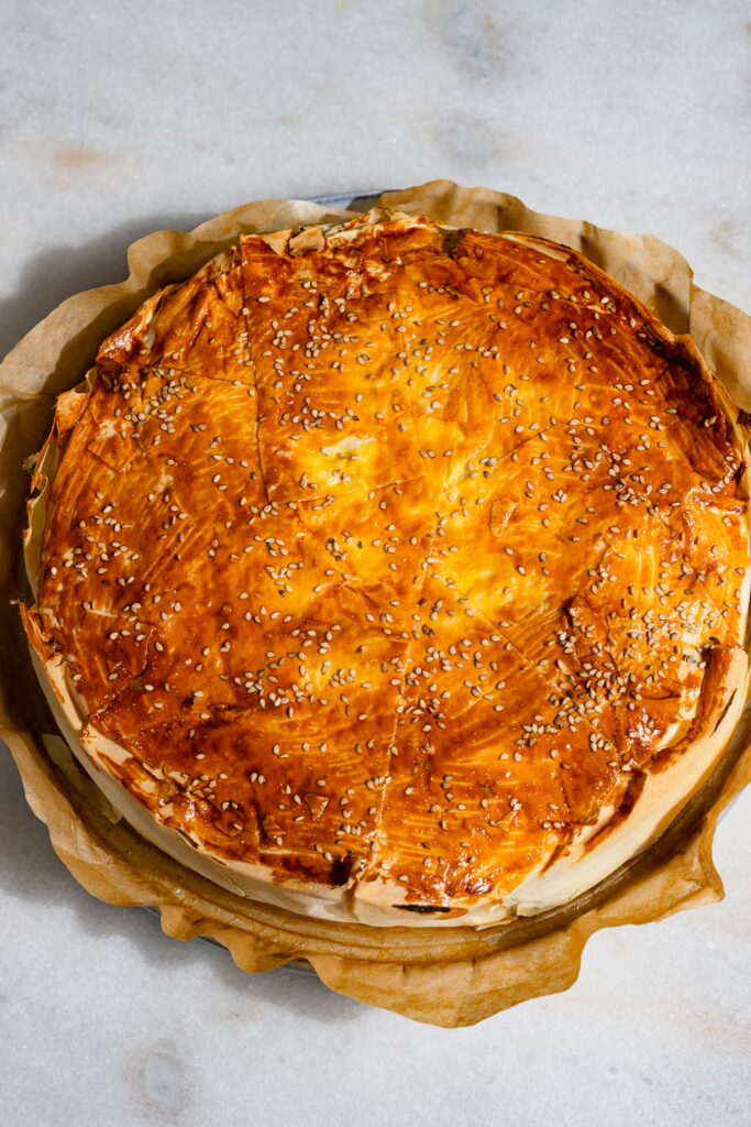 Le börek fourré aux pommes de terre est posé sur un papier sulfurisé sur une table.