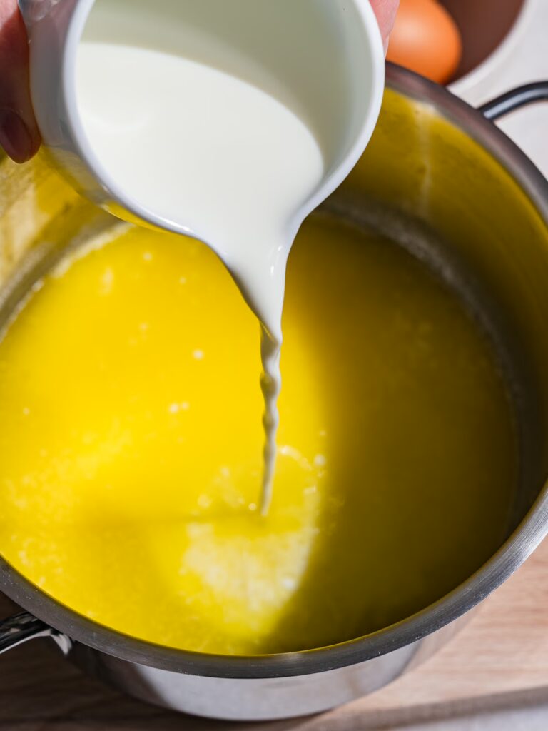 Le lait est versé dans la casserole contenant le beurre fondu.