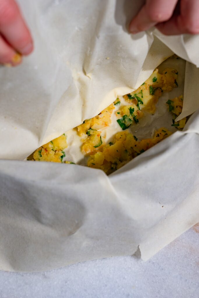 Une feuille de pâte est placée sur la farce du börek de pommes de terre.