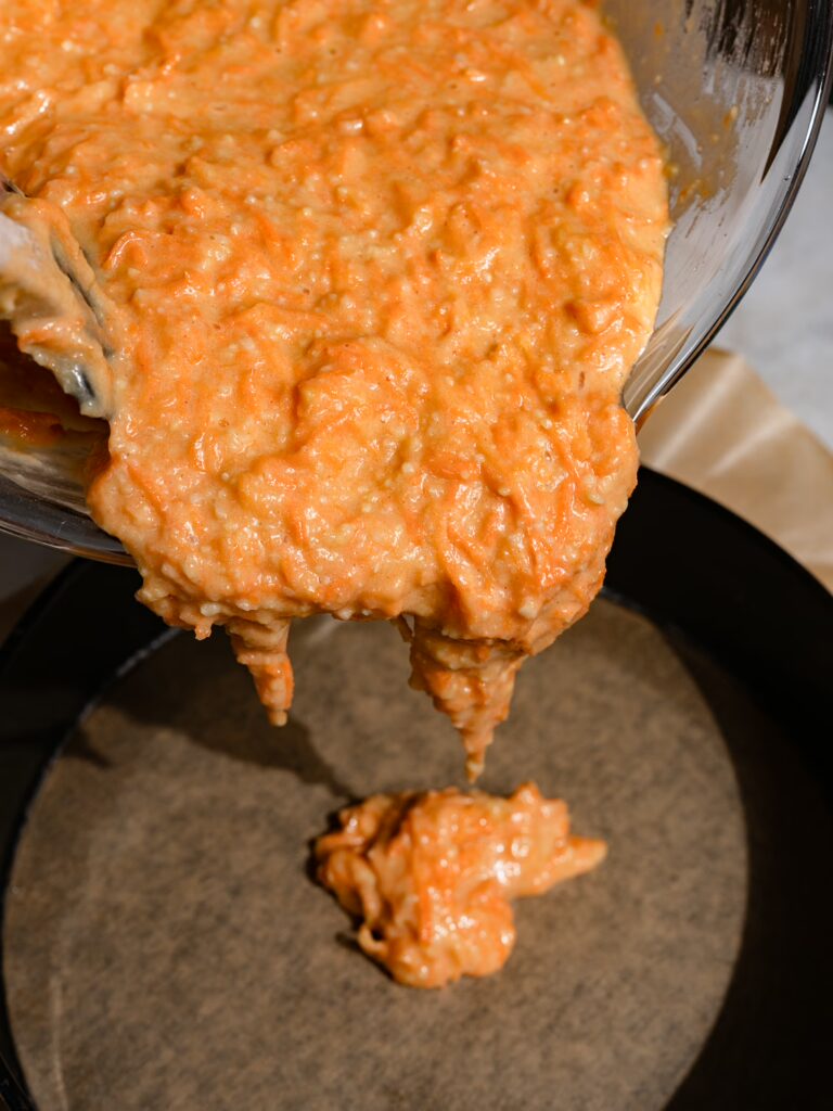 Karottenkuchenteig wird in eine Springform gegeben.