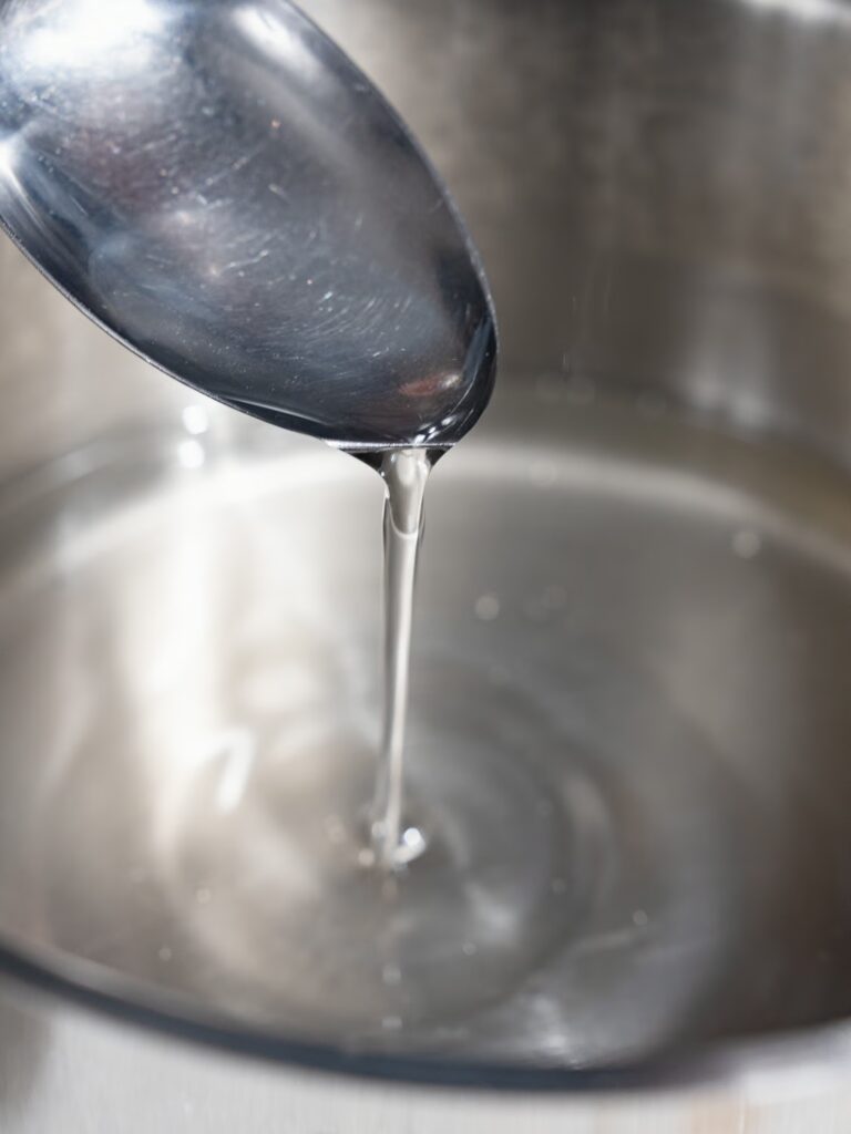 El jarabe de azúcar fluye de una cuchara