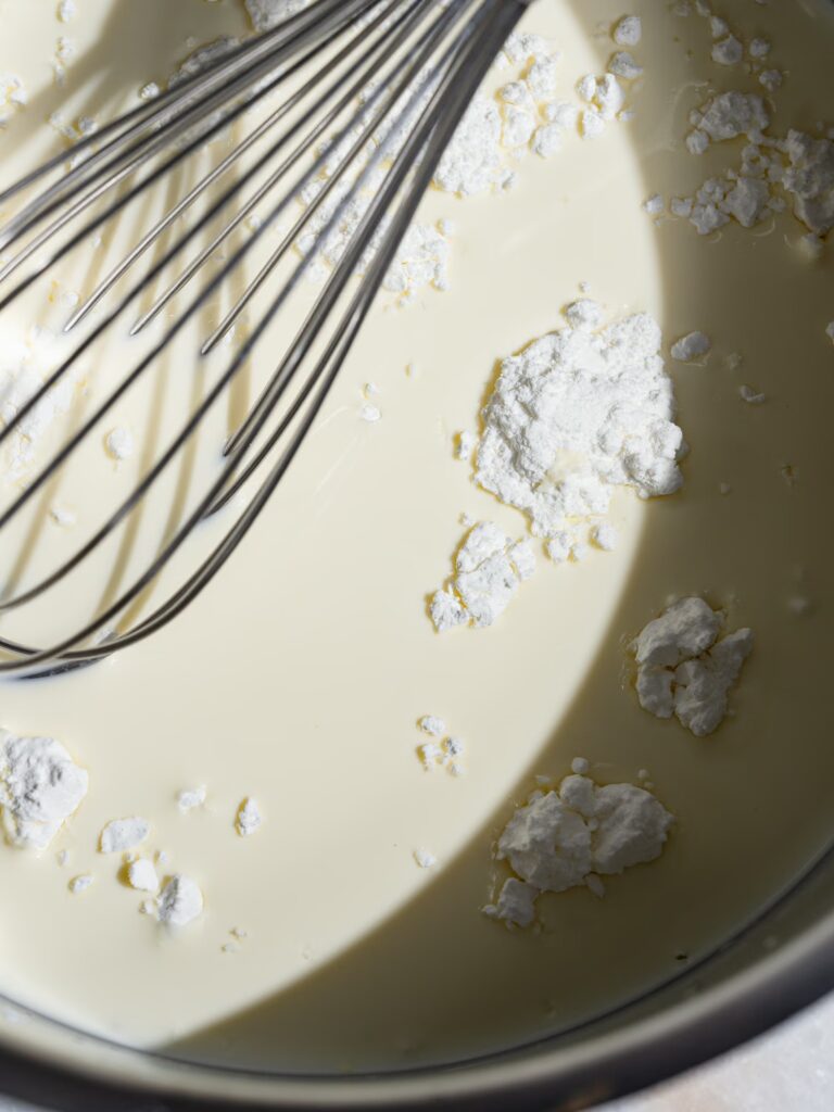 Mezcla la nata, la leche y la harina de maíz en un cazo con un batidor.