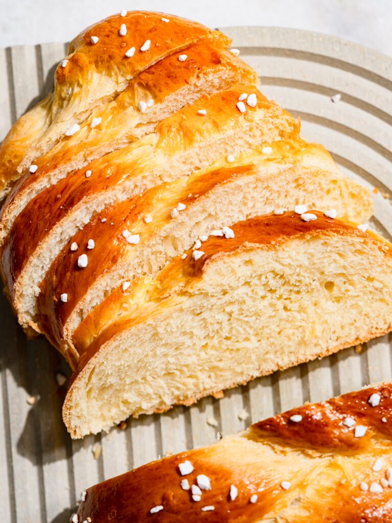 Butterzopf in Scheiben geschnitten auf einem Brett.