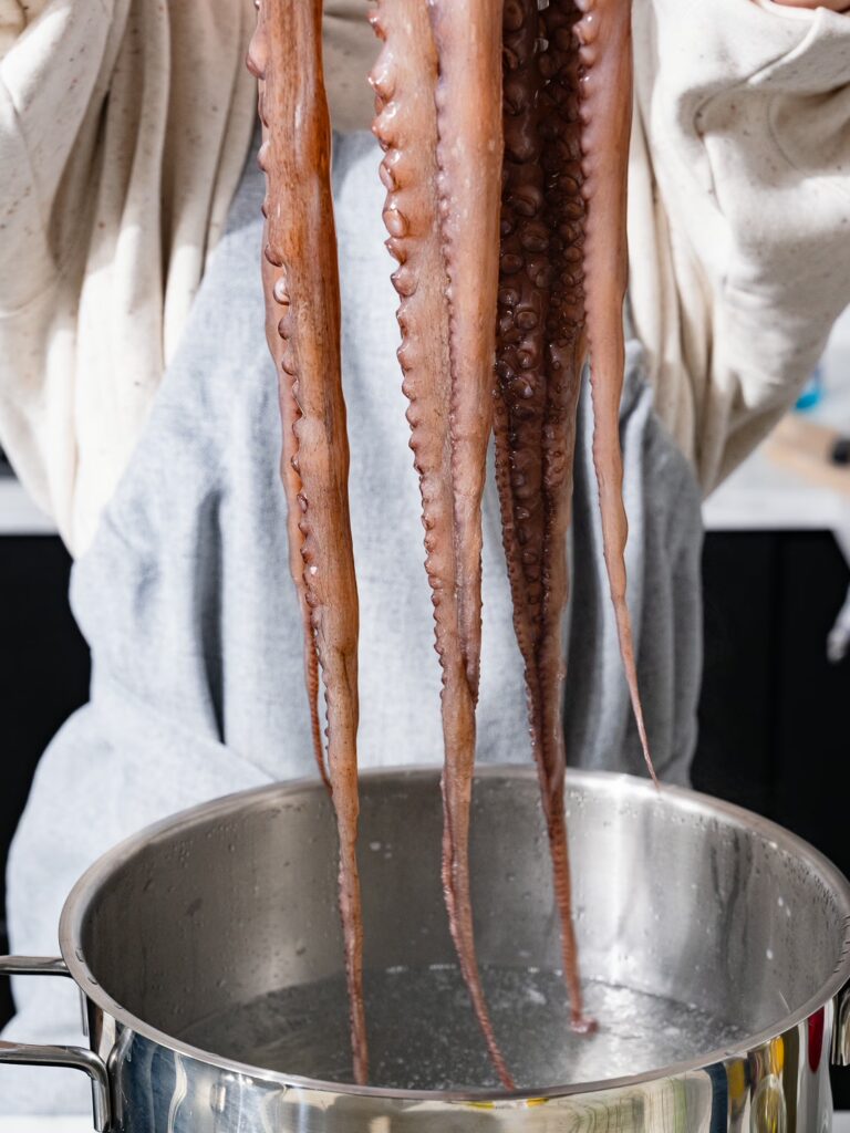 Los tentáculos del pulpo se sumergen en agua caliente.